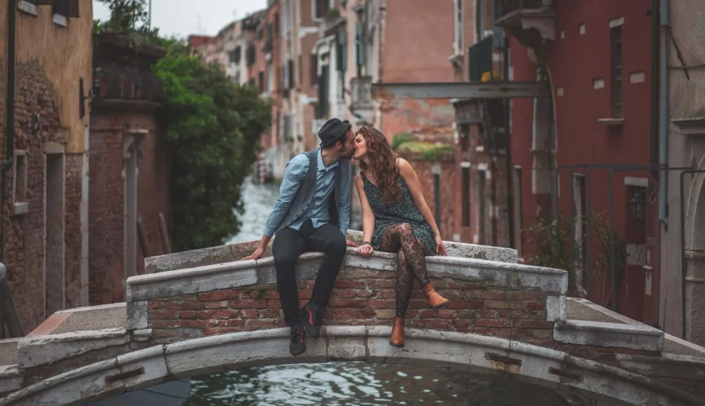 Engagement Venice photo of a couple kissing on Chiodo bridge over a quiet canal in Venice, Italy