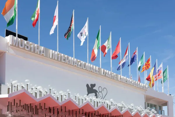 Venice Film Festival 2025 entrance building with international flags and official Biennale signage at Lido venue