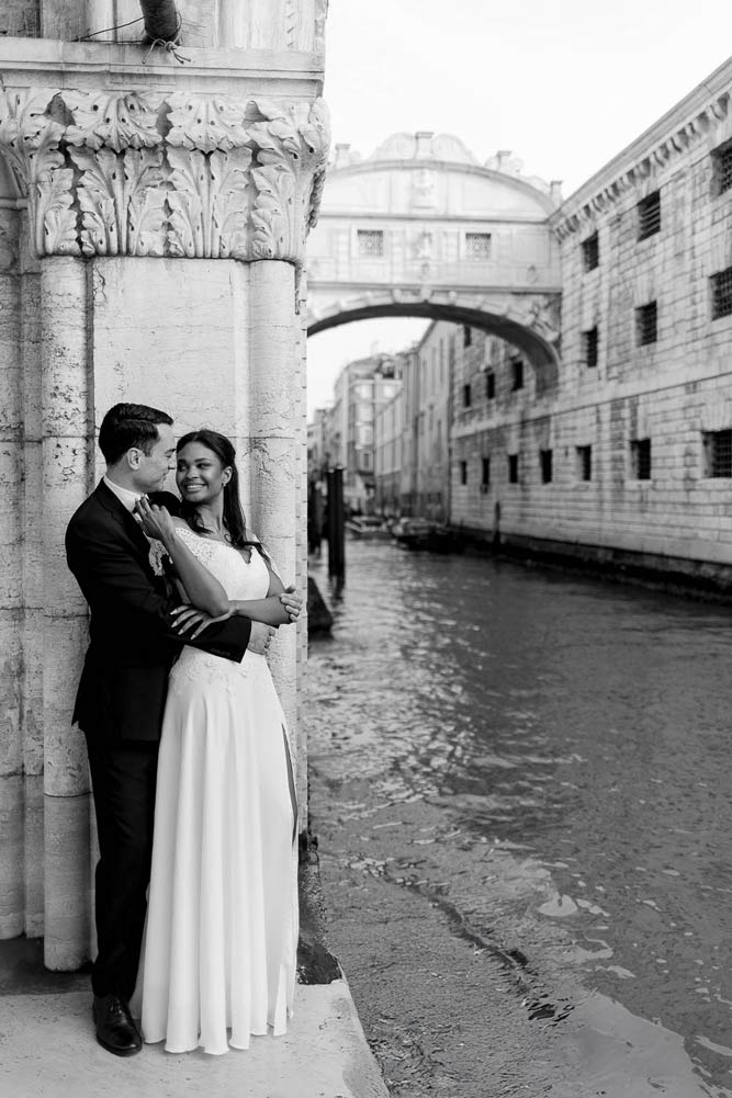 Bride and groom under the bridge of sighs in venice italy